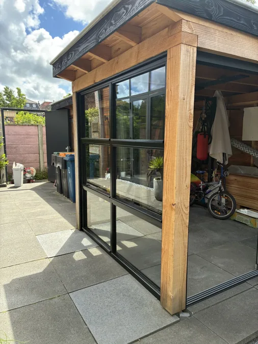Houten schuur met zwarte kozijnen